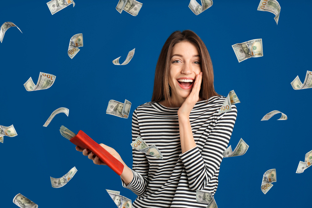 Happy Young Woman Holding Wallet with Money on Blue Background