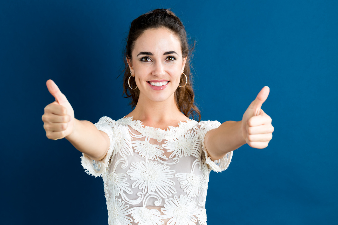 Happy young woman giving thumbs