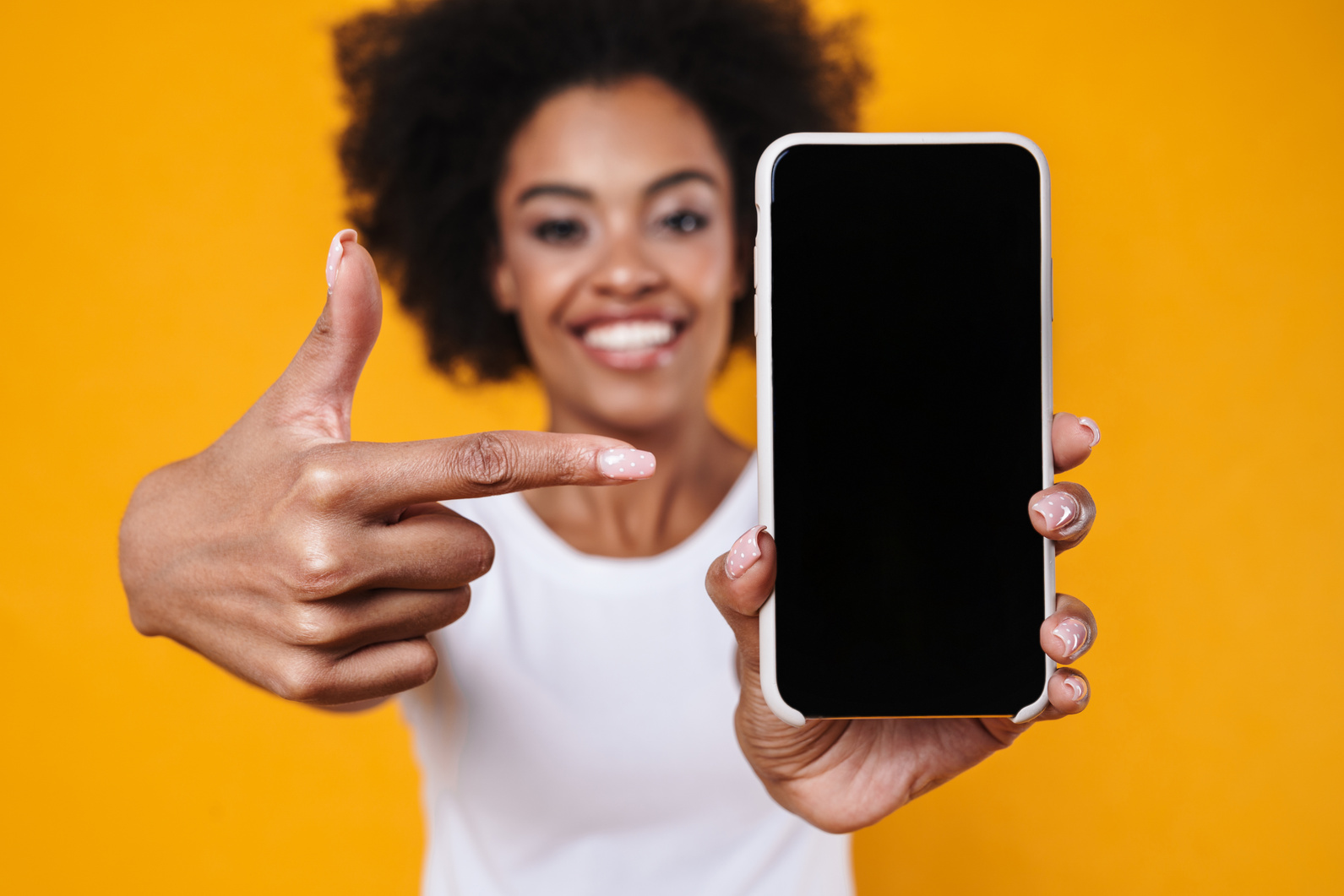 Happy African American Woman Smiling and Pointing Finger at Cellphone
