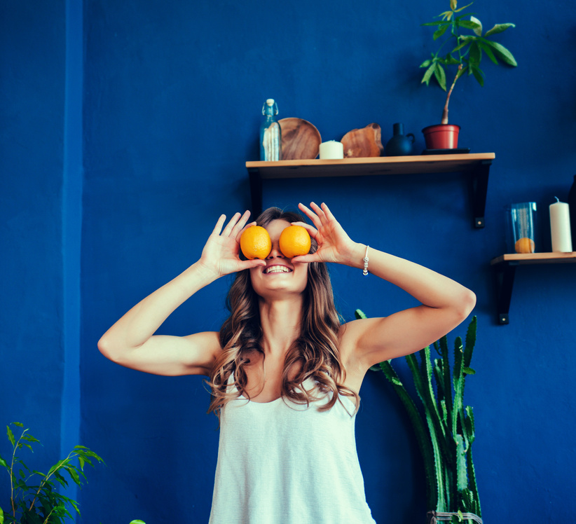 Happy young woman holding oranges